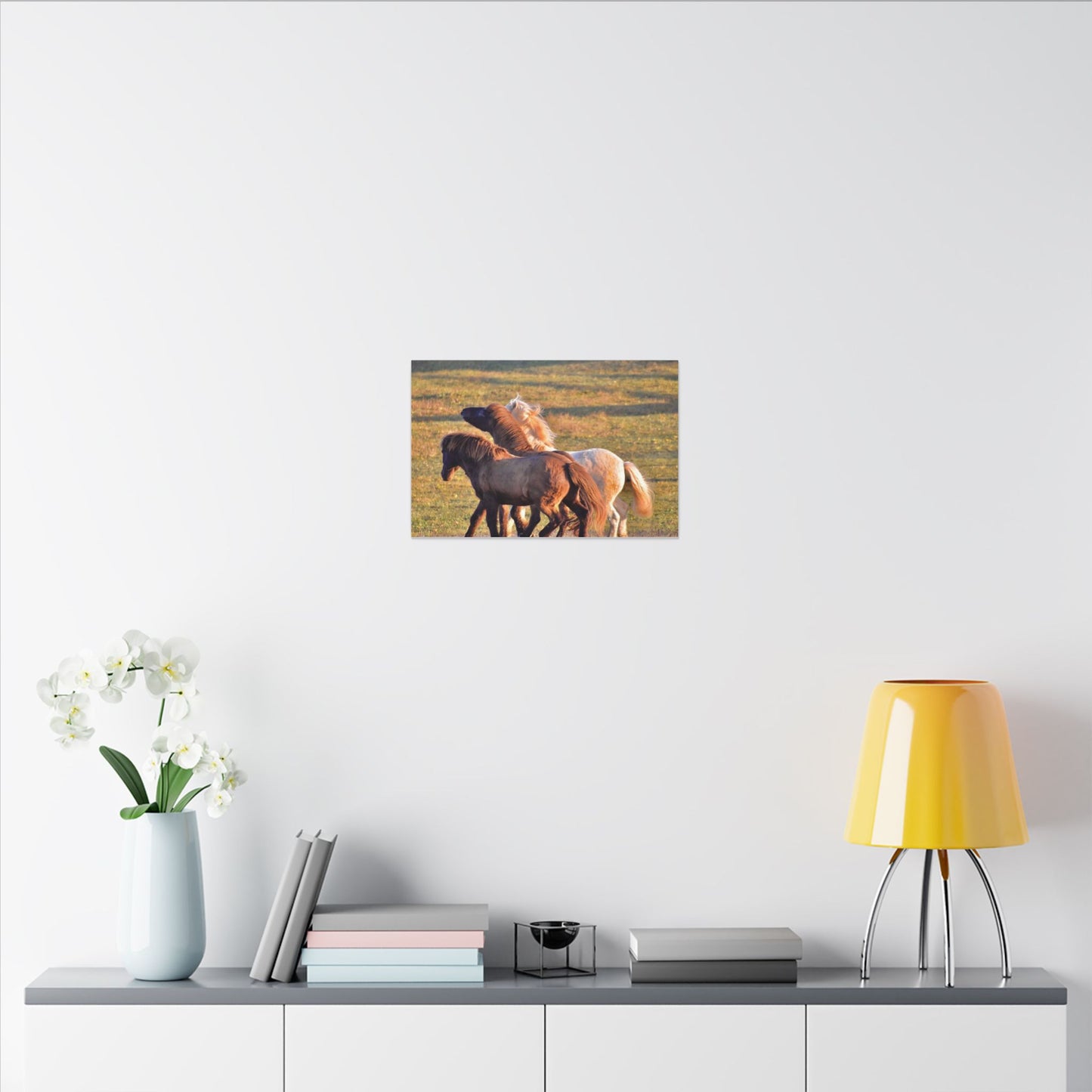 Poster of horses on a wall above a shelf with decor items.
