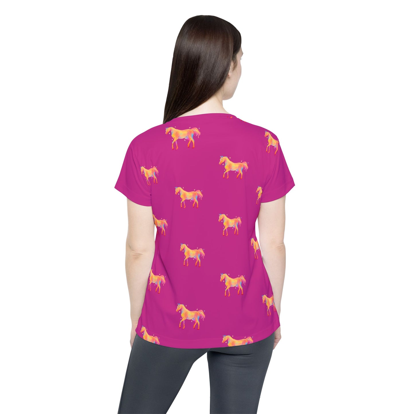 Person wearing a pink t-shirt with horse patterns on a white background