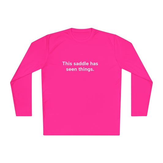 Pink long-sleeve shirt with text 'This saddle has seen things.' on a white background