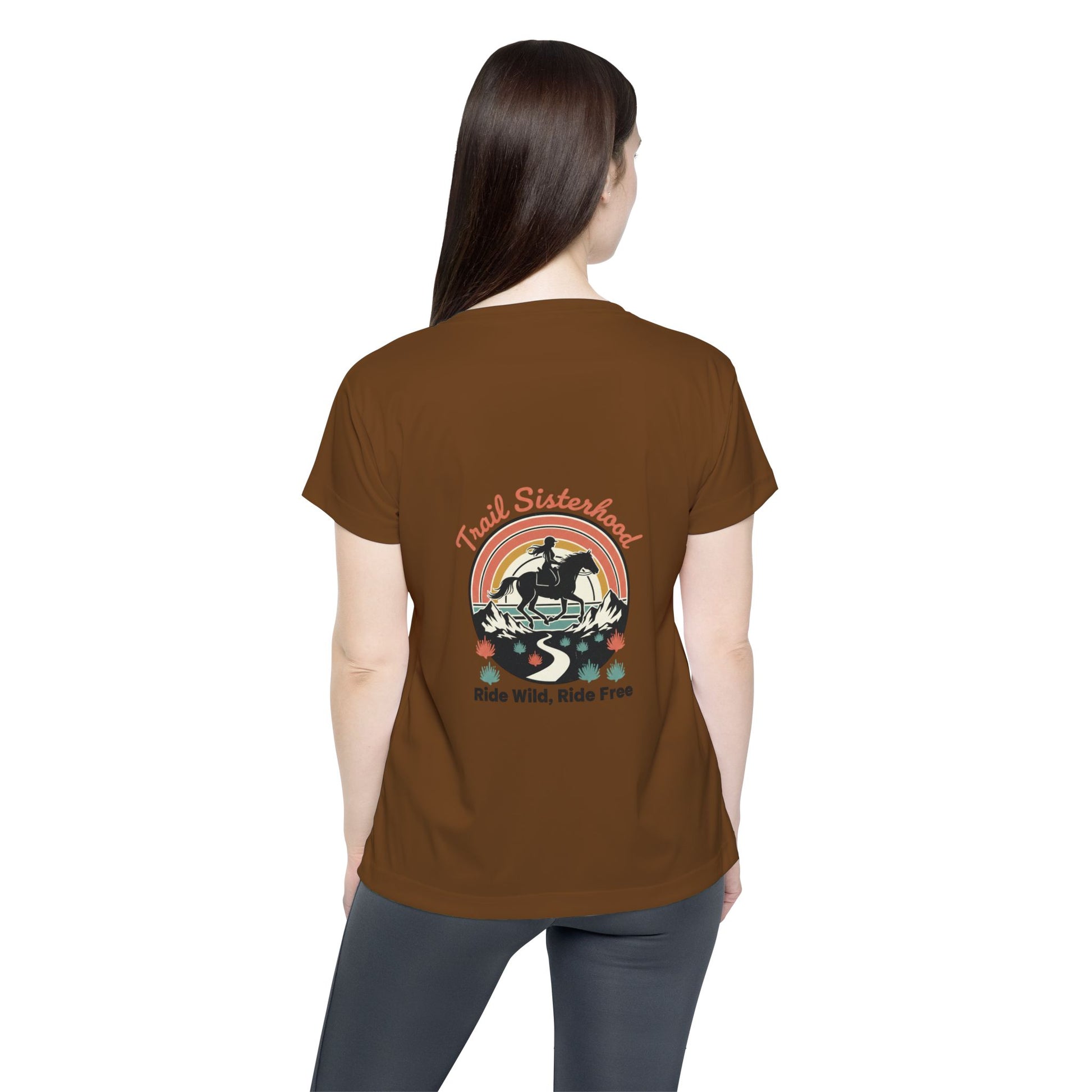 Woman wearing a brown t-shirt with a graphic design on the back, standing against a white background
