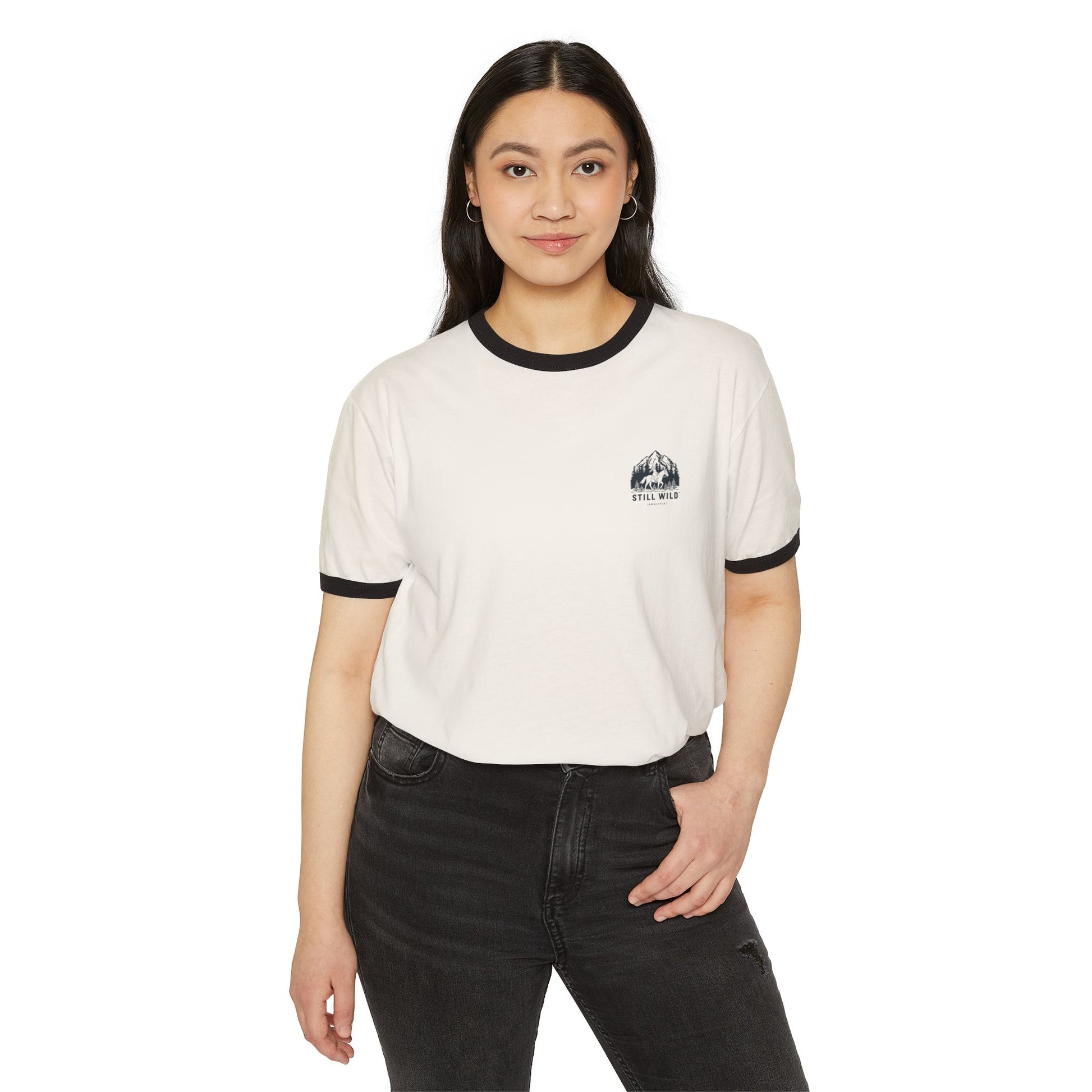 Front image:
Retro ringer tee with "Still Wild" graphic across the chest in distressed vintage print, contrast 1x1 rib binding at the collar and sleeves.
Back image:
Back of the same retro ringer tee showing a faded silhouette of a woman riding a horse, vintage tour-tee styling.