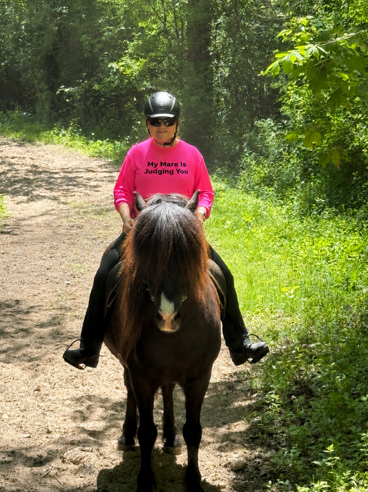Rider on Icelandic horse wearing My Mare Is Judging You hot pink long sleeve trail shirt